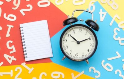 Notepad and clock on colourful background